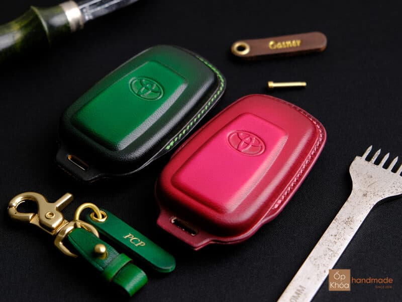 Smartkey Toyota Corolla Cross đặt cạnh bao da chìa khóa thủ công.