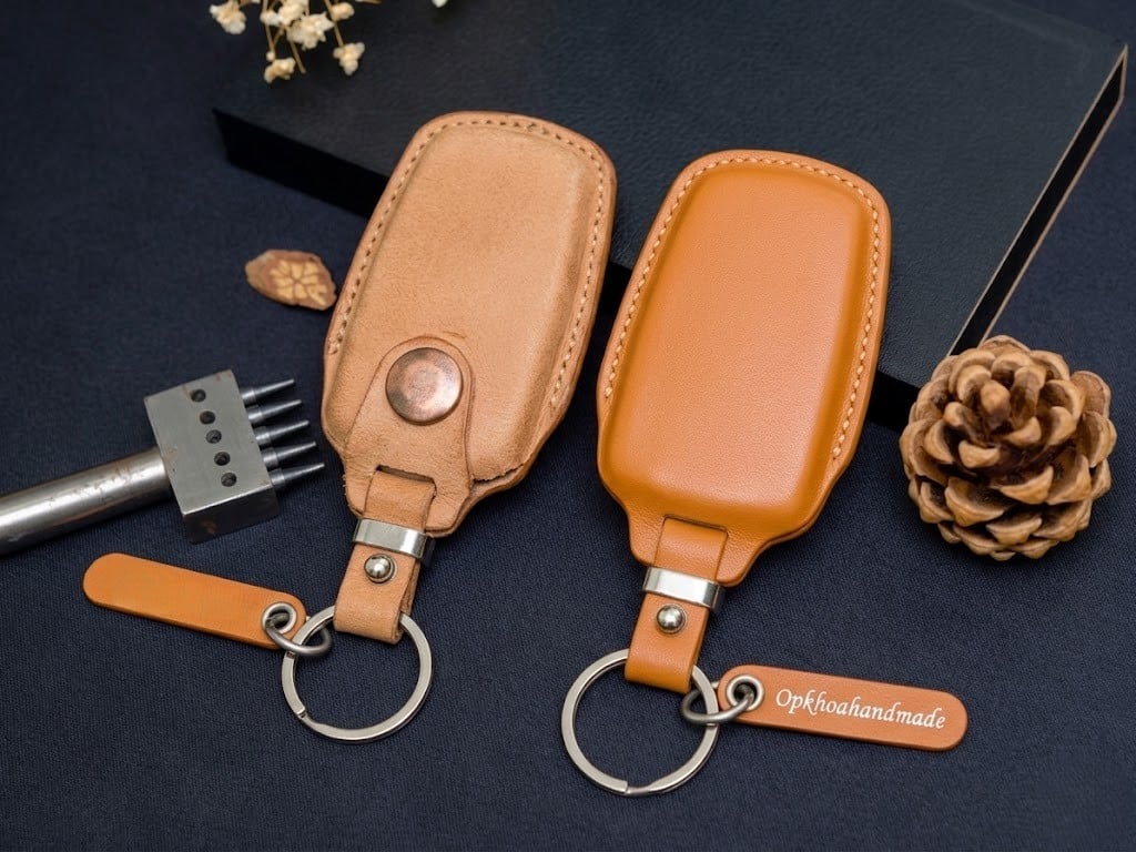 So sánh bao da chìa khóa đính kim loại cản sóng sạc và bao da lưng phẳng.